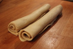 Kanelsneglene er rullet sammen og klar til at blive skåret